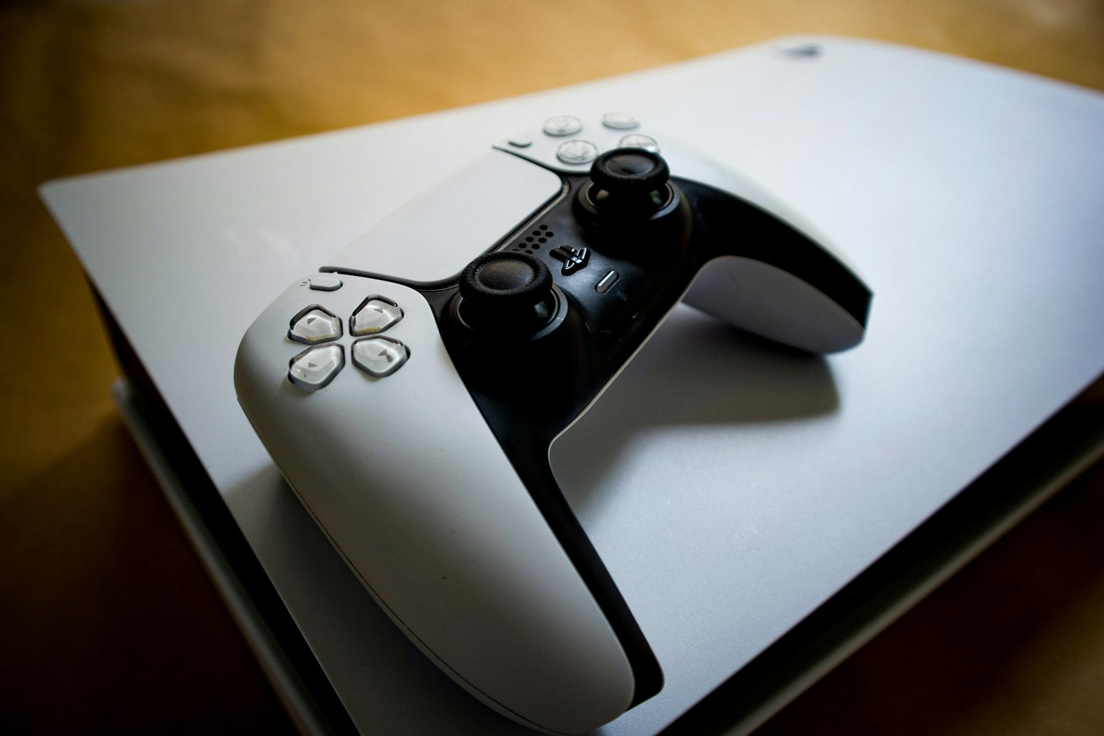 Consola PlayStation 5 con su mando DualSense apoyado encima